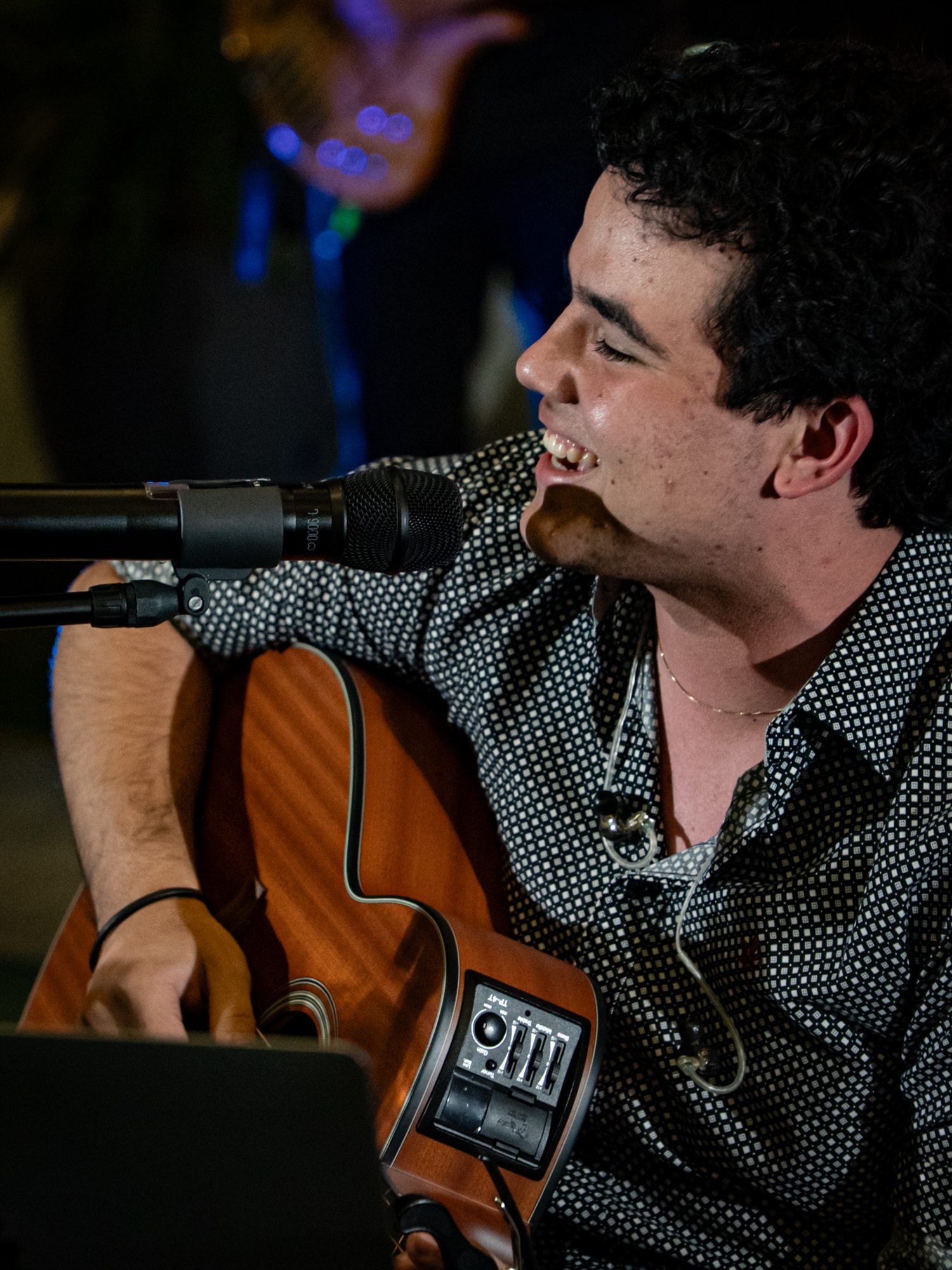 Caio Borges cantando e tocando violão em close
